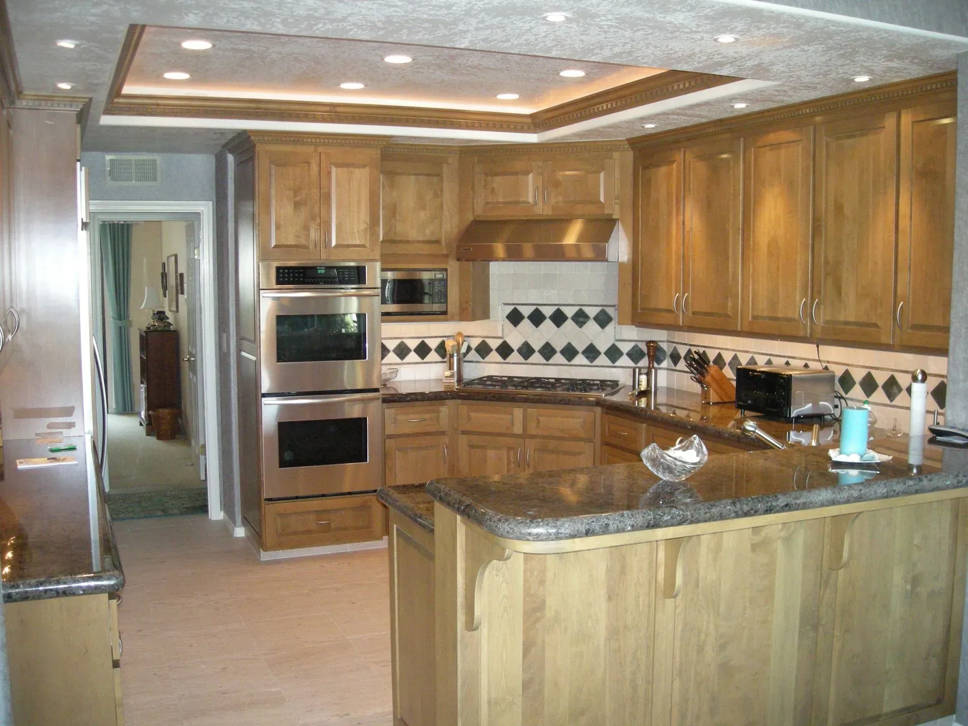 Modern kitchen with wood cabinets, granite island, and stainless steel appliances