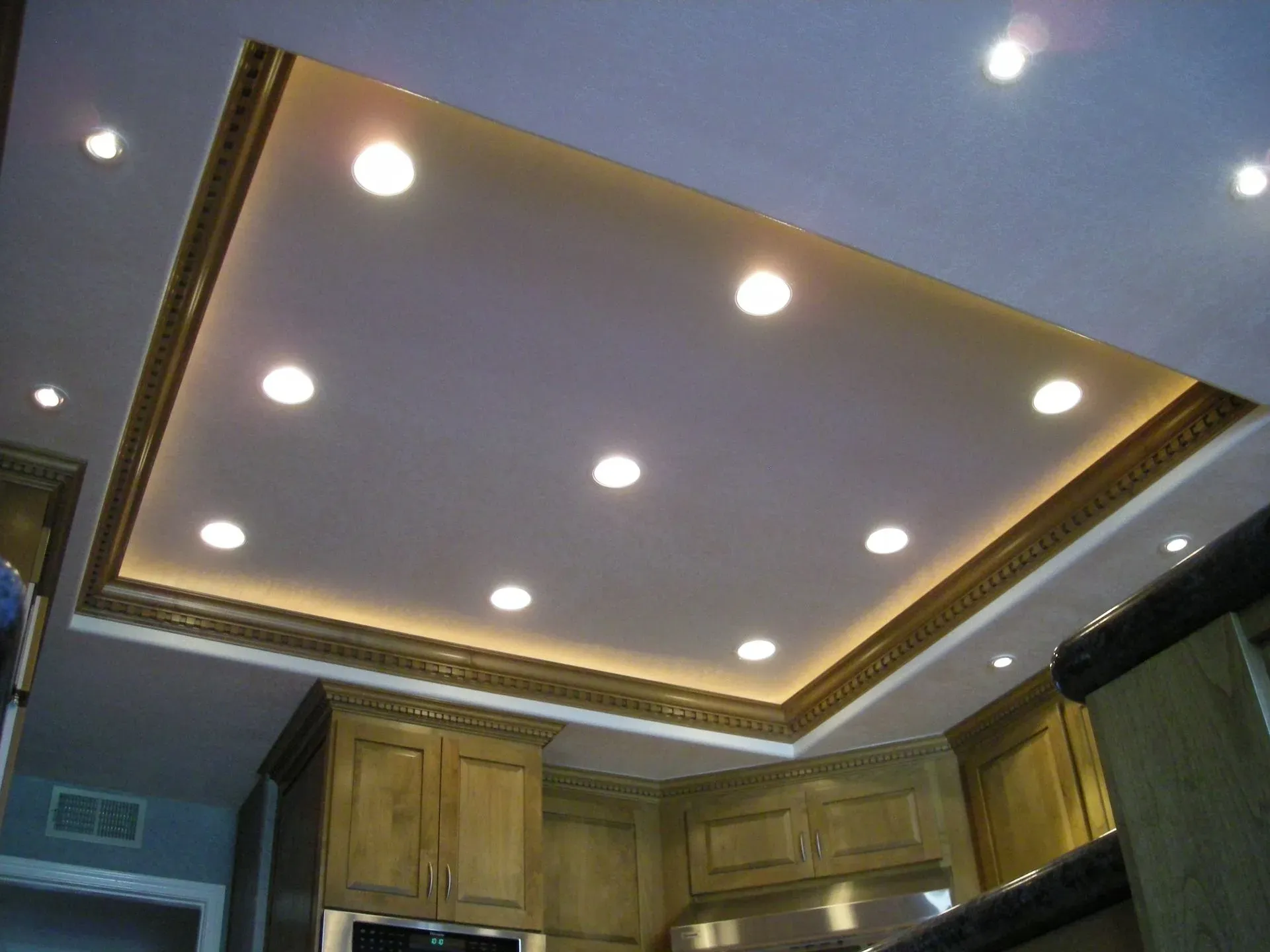 Kitchen ceiling with recessed lights and wood cabinetry below