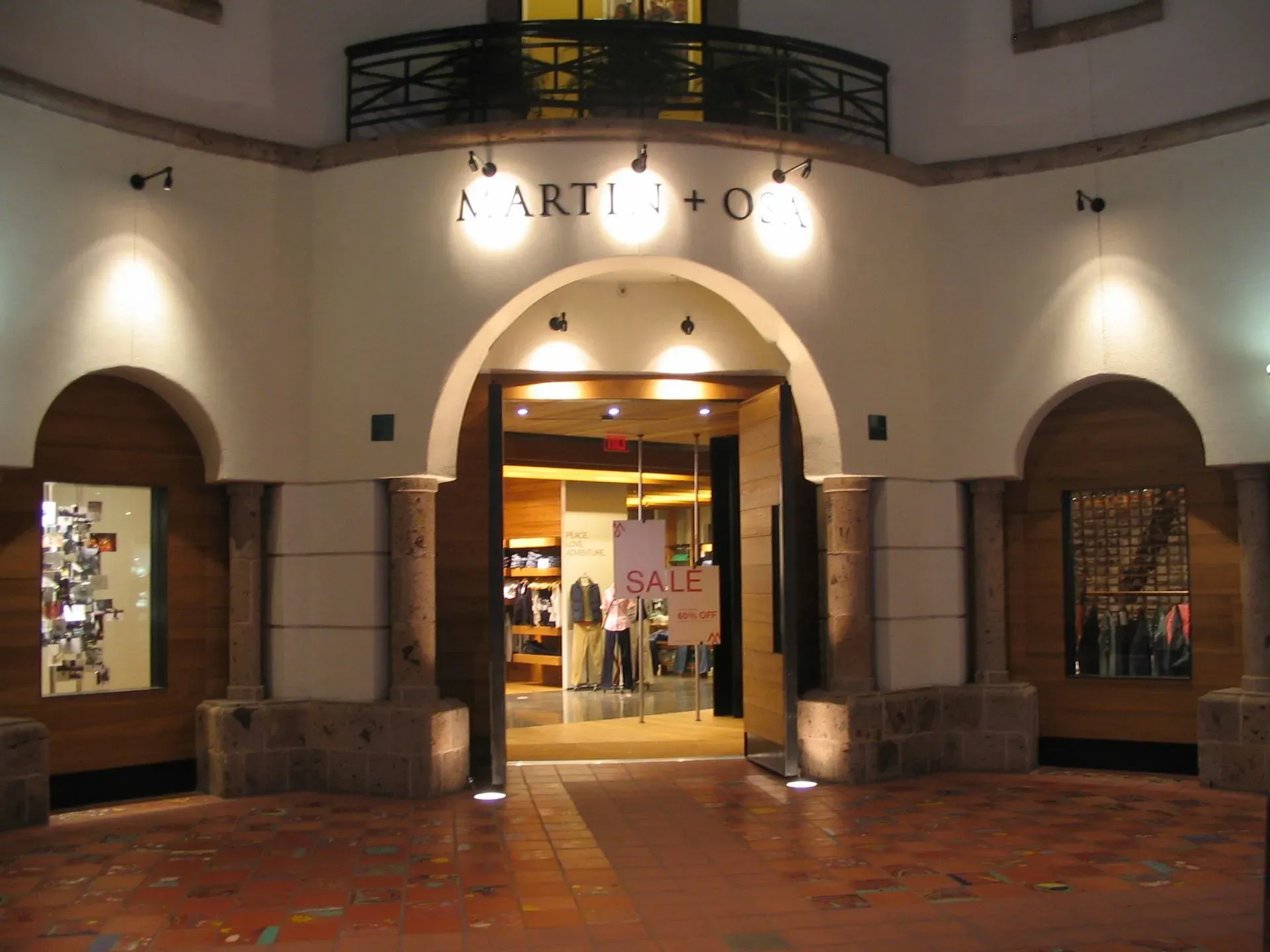 Illuminated storefront entrance at night with arched doorway and warm interior lighting