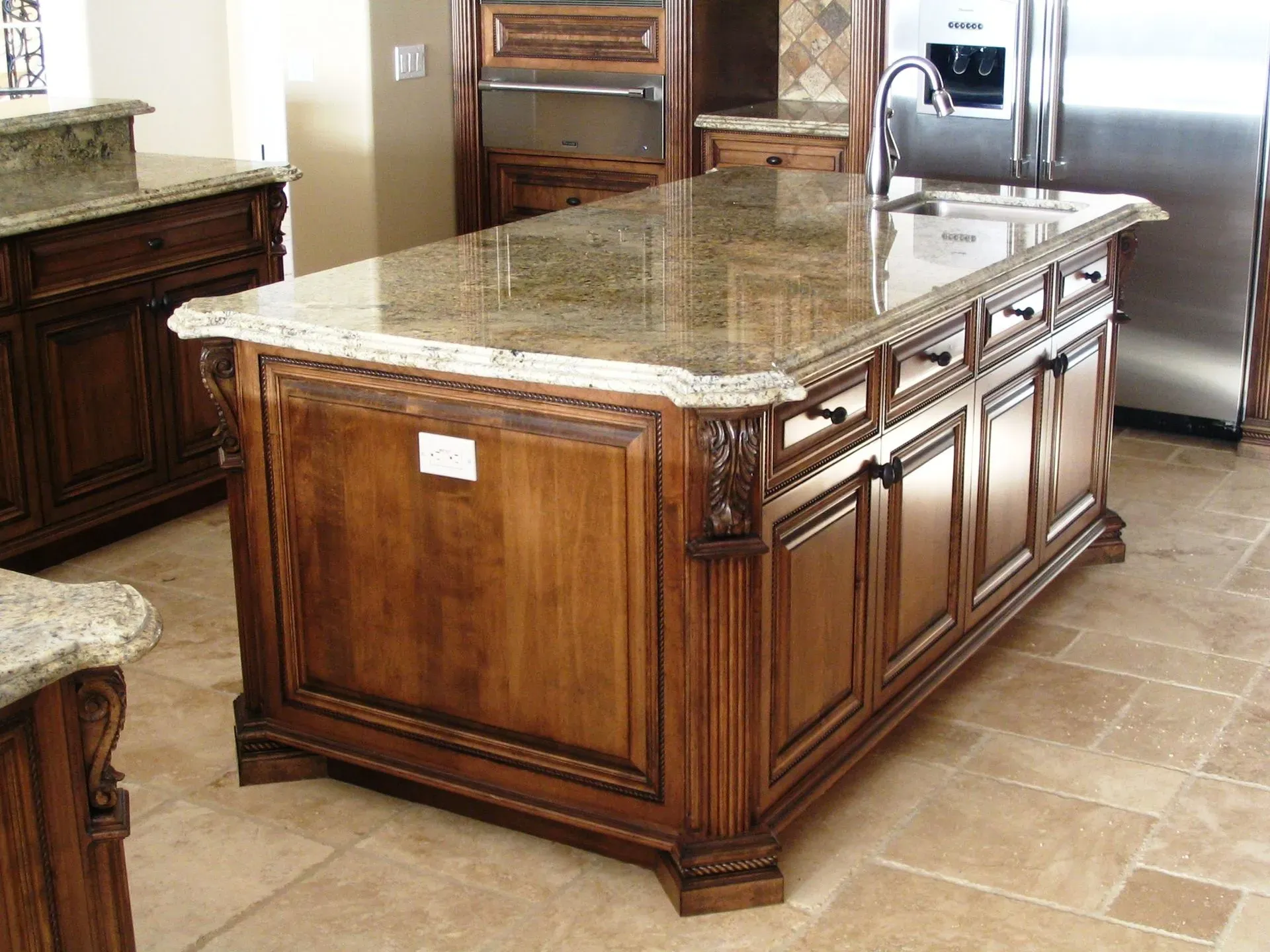 Kitchen island with dark wood cabinets and a granite countertop in a tiled kitchen