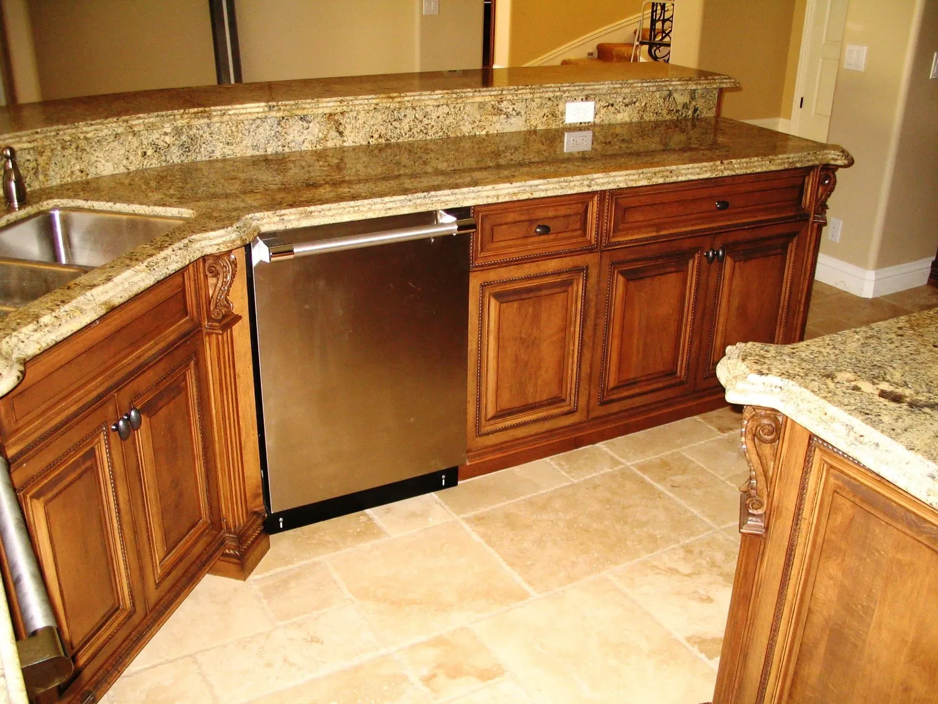 Kitchen with granite countertop, wooden cabinets, stainless dishwasher, and tiled floor