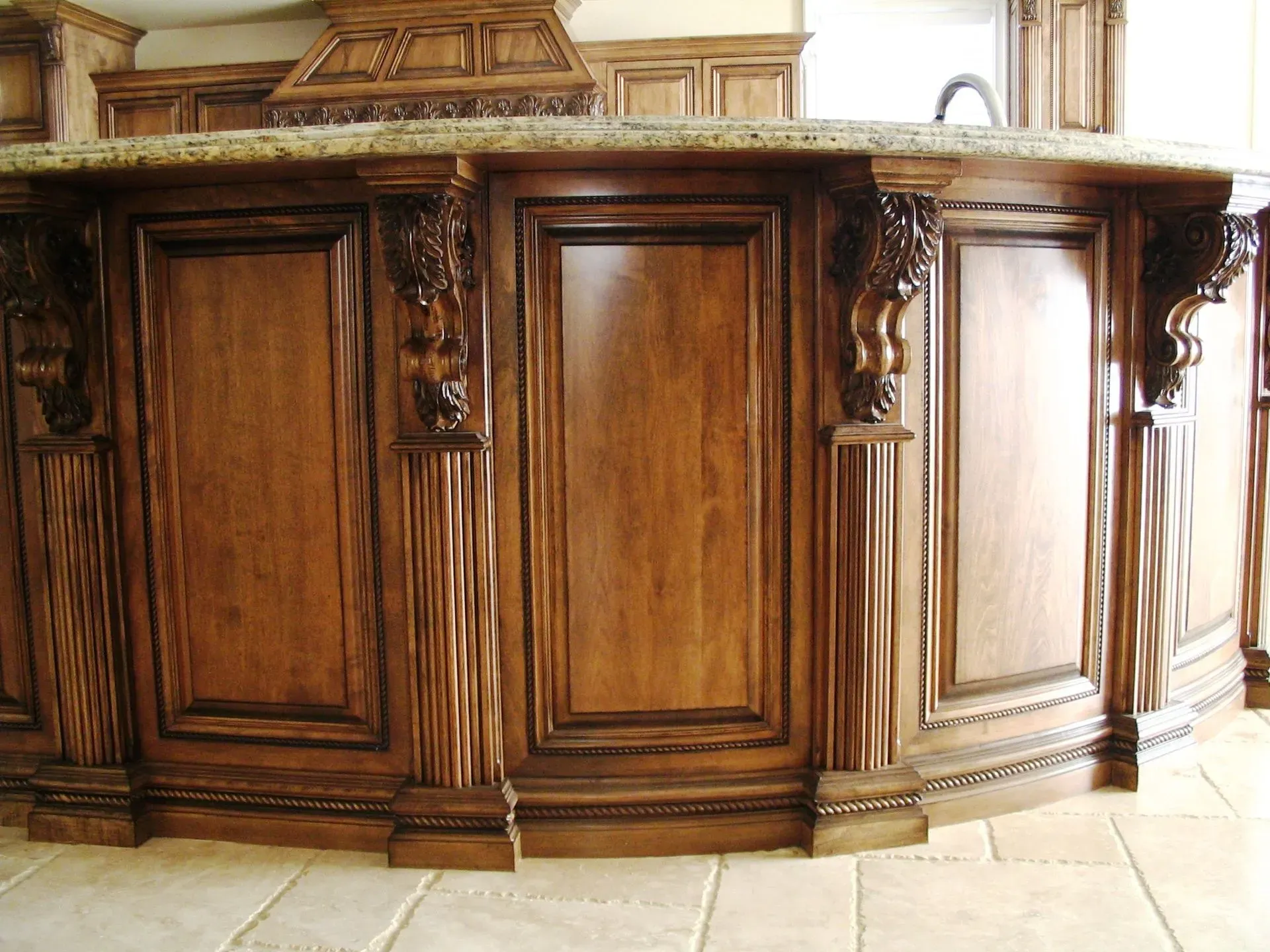 Ornate wooden bar counter with carved panels and marble top in a formal interior