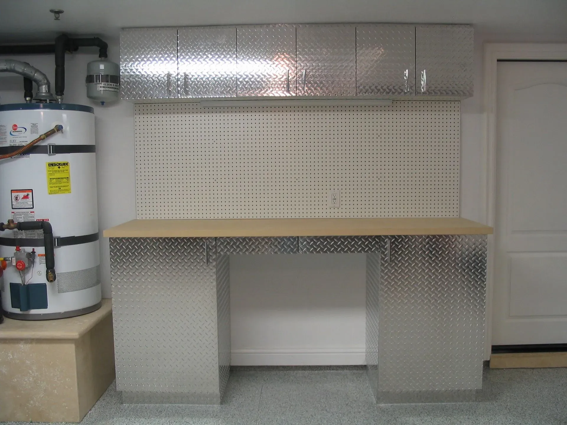 Metal workbench with pegboard wall and cabinets in a garage or utility room