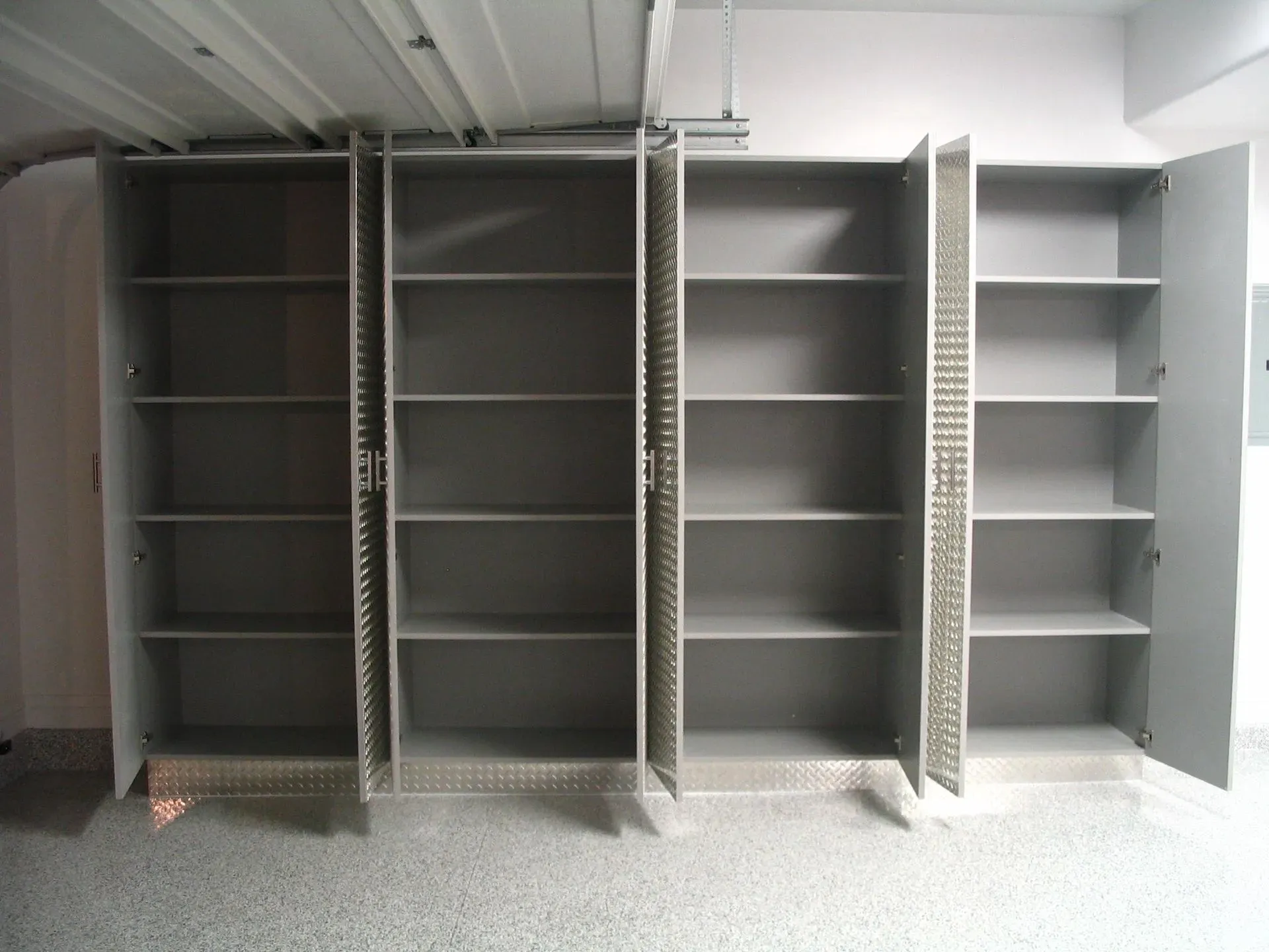 Empty gray metal shelving units in a storage room beneath a sloped ceiling
