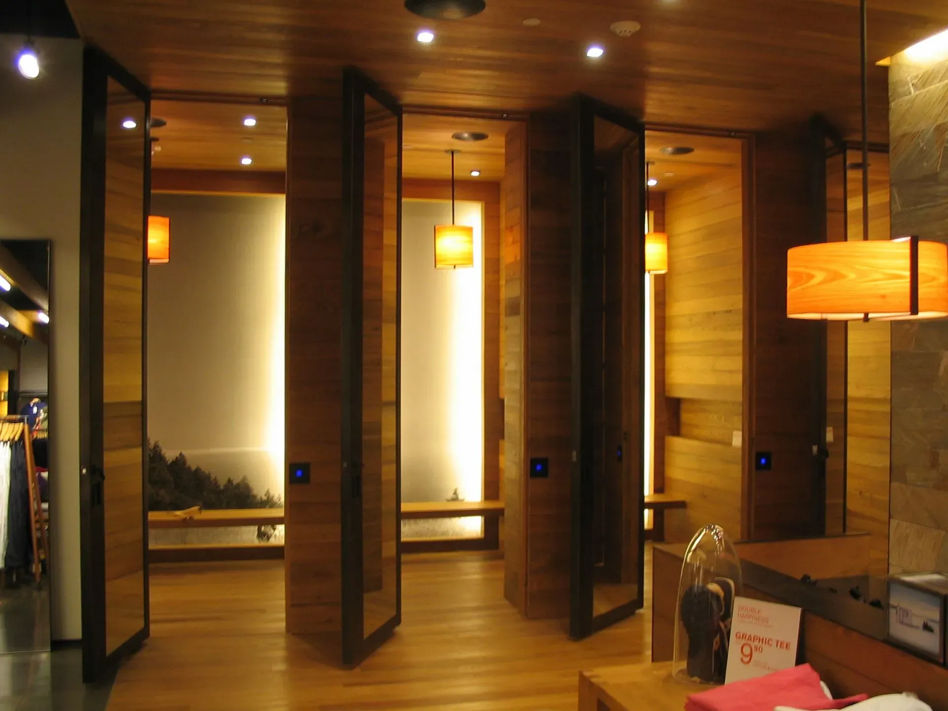 Warm wood-paneled spa or hotel interior with hanging lantern lights and open private seating alcoves.