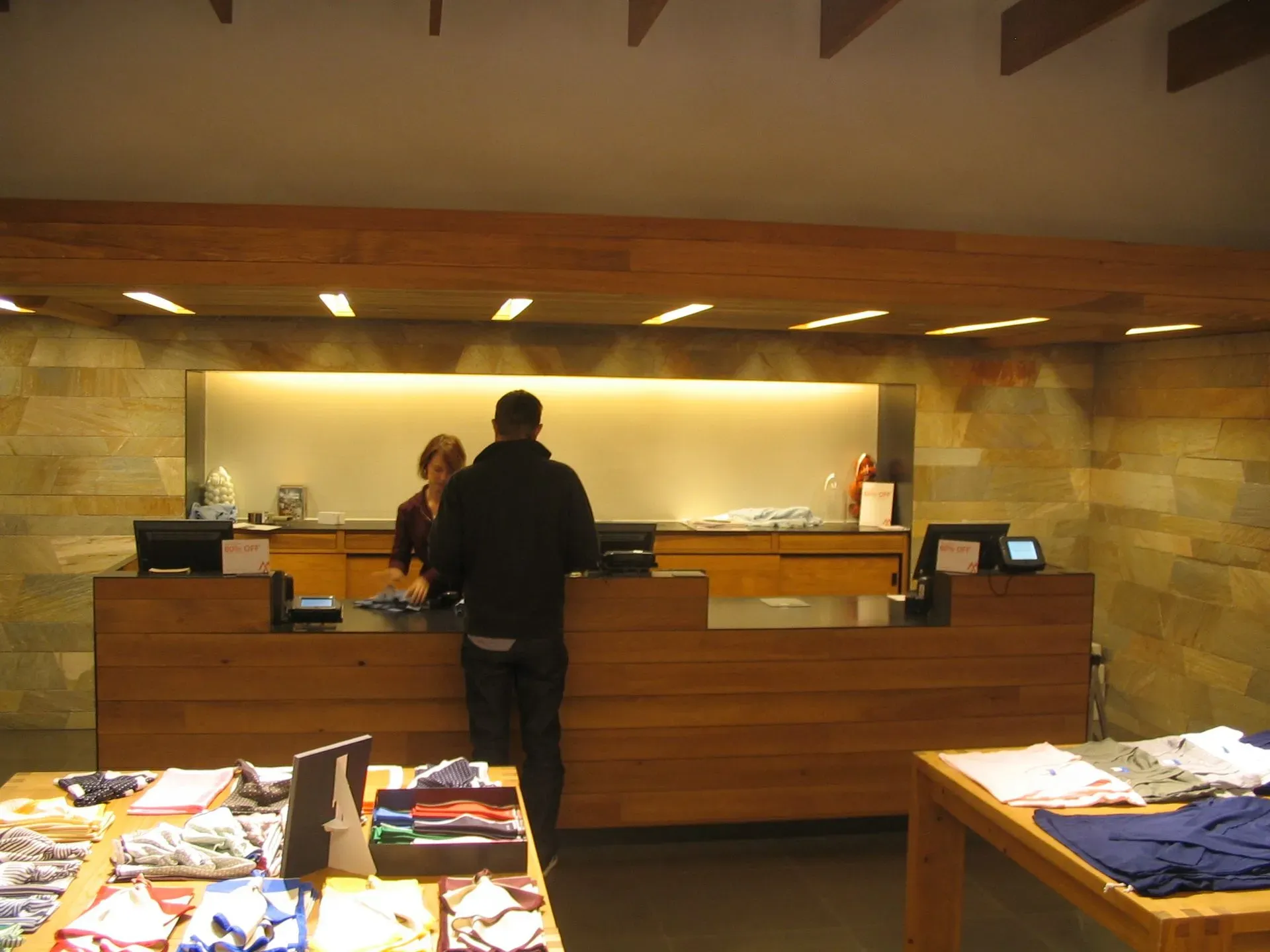 Hotel lobby check-in counter with a guest standing before staff under warm lighting.