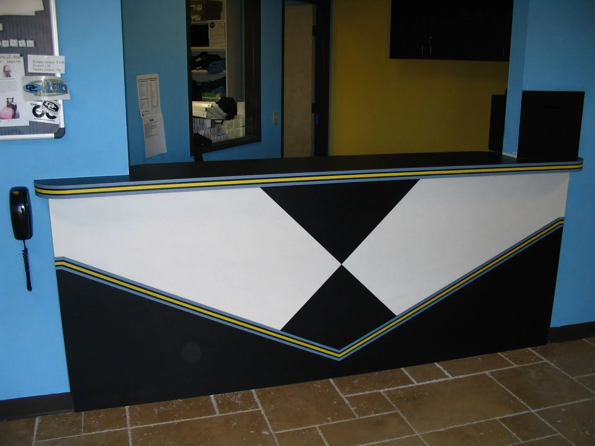 Black-and-white geometric bar counter in a blue-walled indoor space