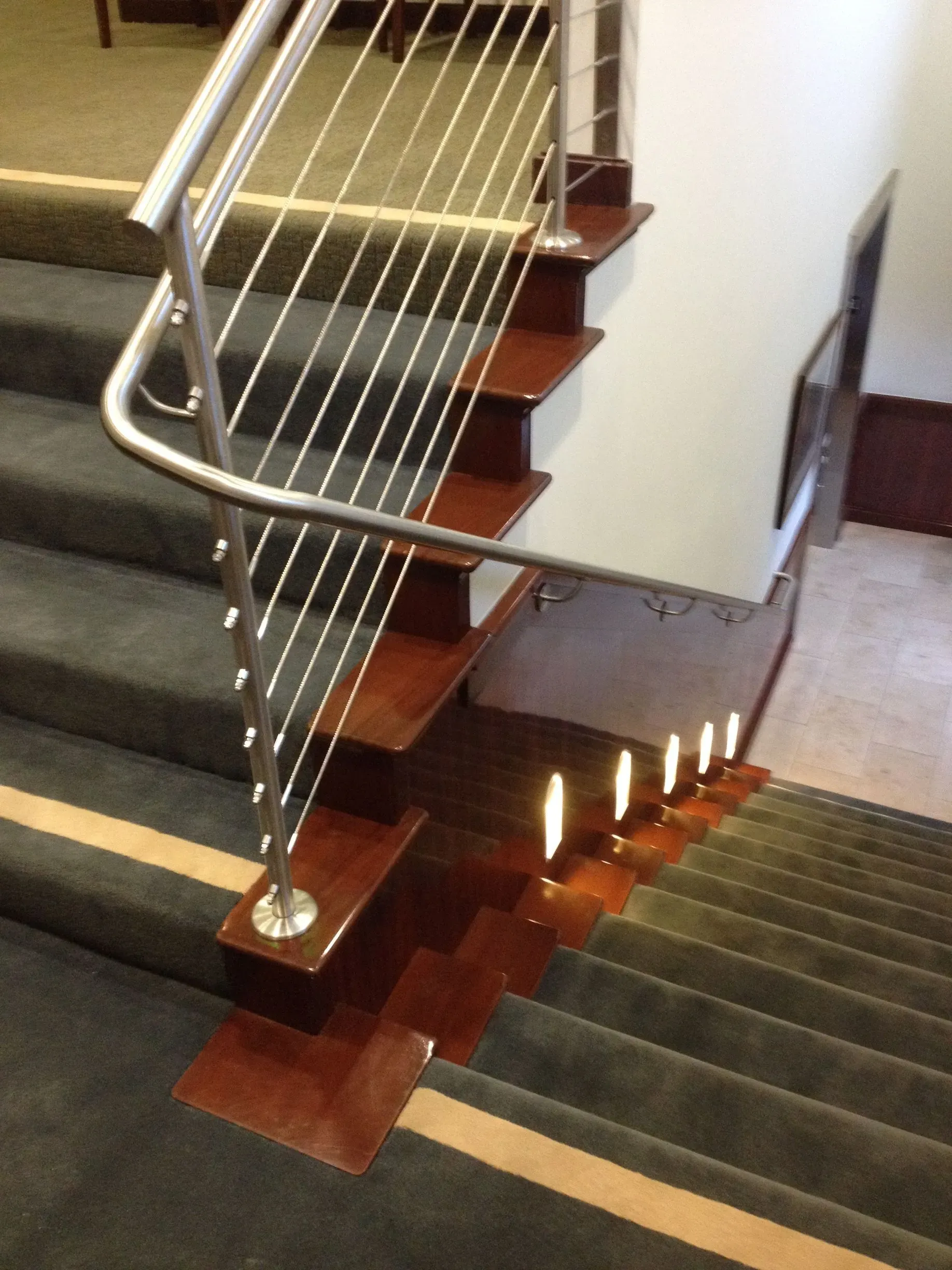 Wooden stair landing with metal railing and candlelit steps in a building interior