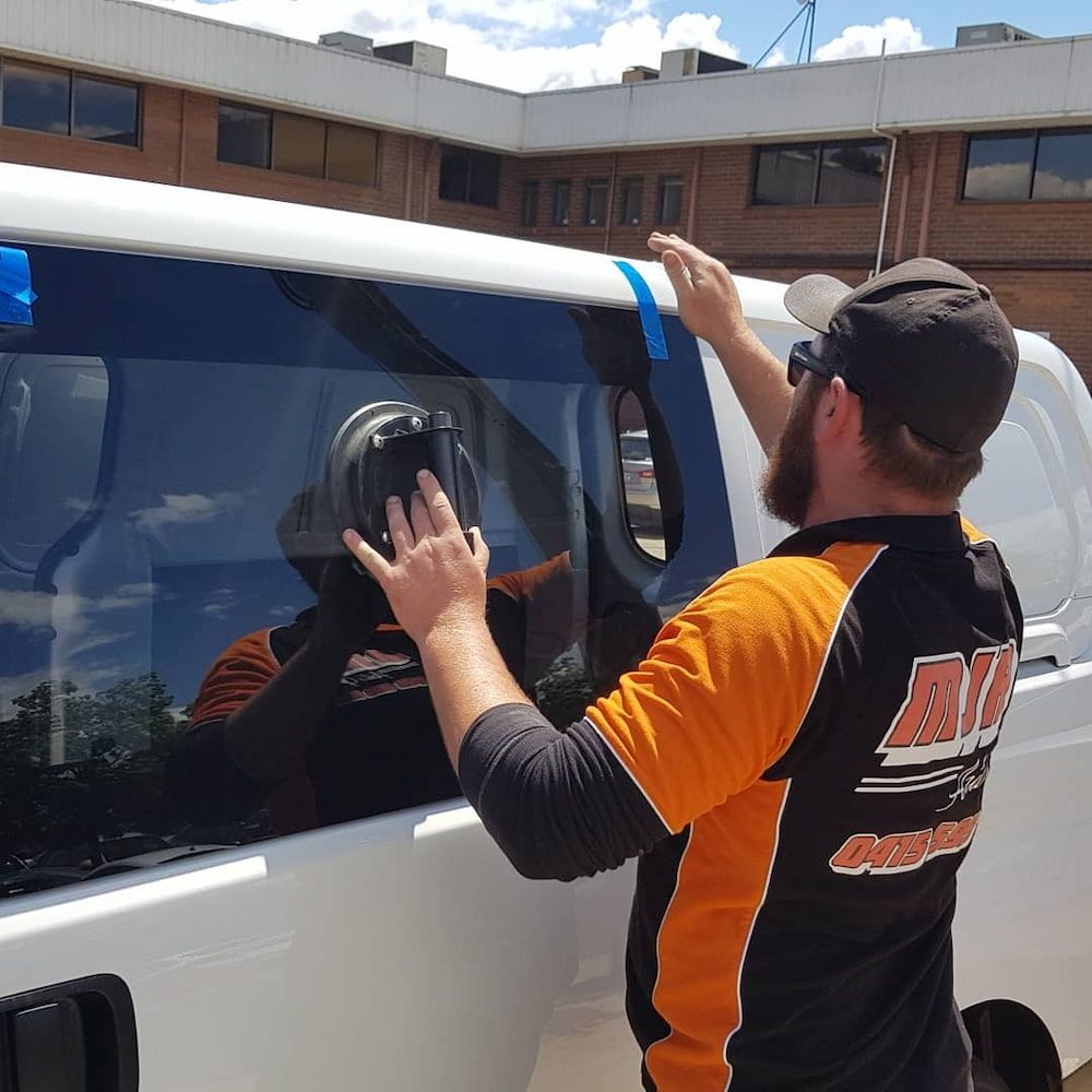 A Man Wearing an Orange and Black Shirt That Says 'All Terrain' on It — MJR Auto Glass In Moss Vale, NSW