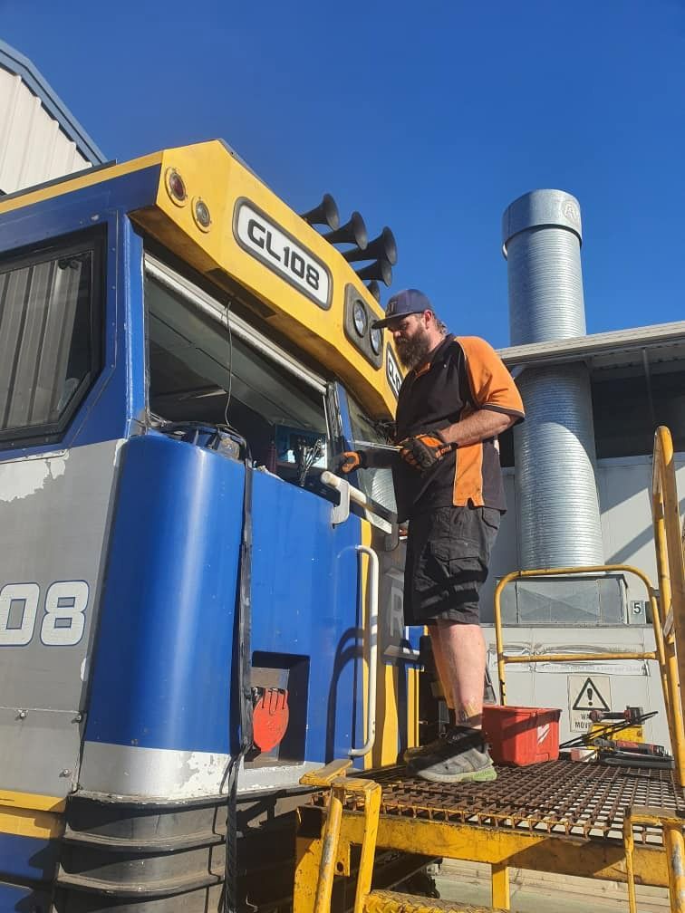 A Man Is Working On A Blue And Yellow Vehicle That Says Glide — MJR Auto Glass In Goulburn, NSW
