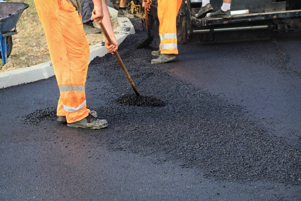 A team applying a layer of asphalt to a surface near Georgetown, Kentucky