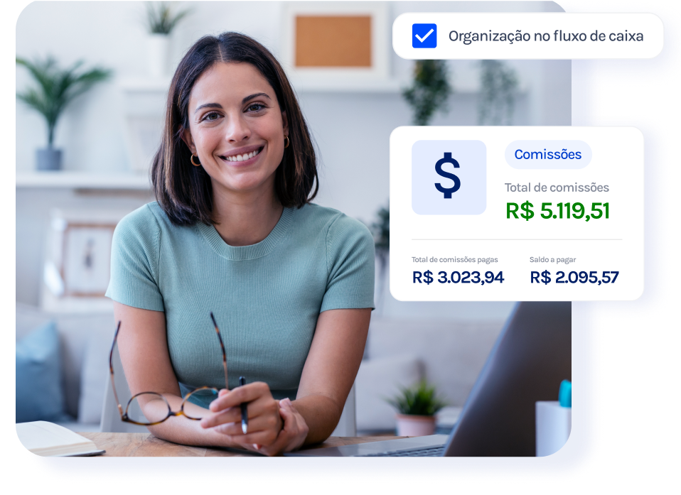 Uma mulher está sentada em uma mesa com um laptop e sorrindo.