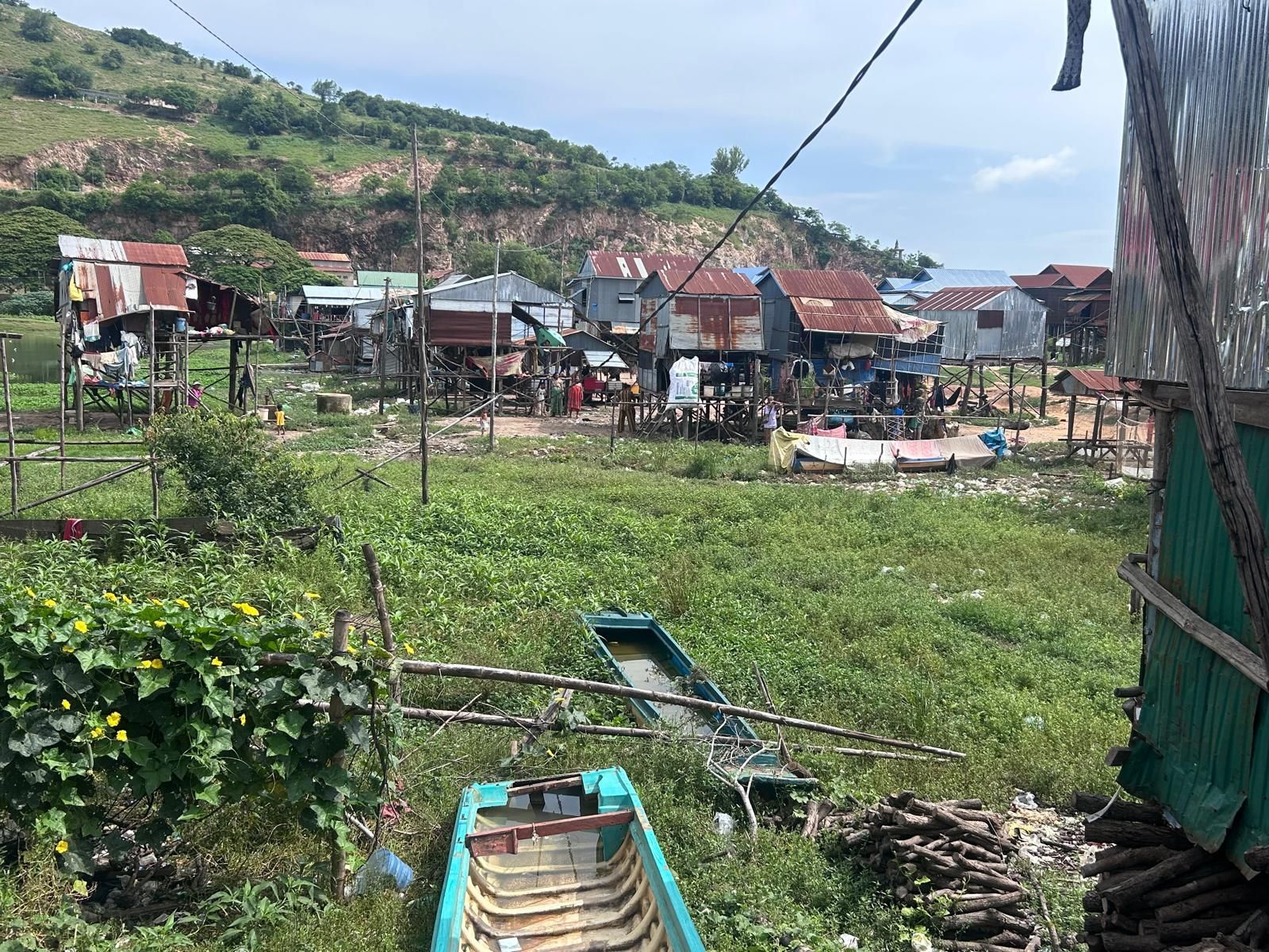 A boat is sitting in the grass in front of a village.