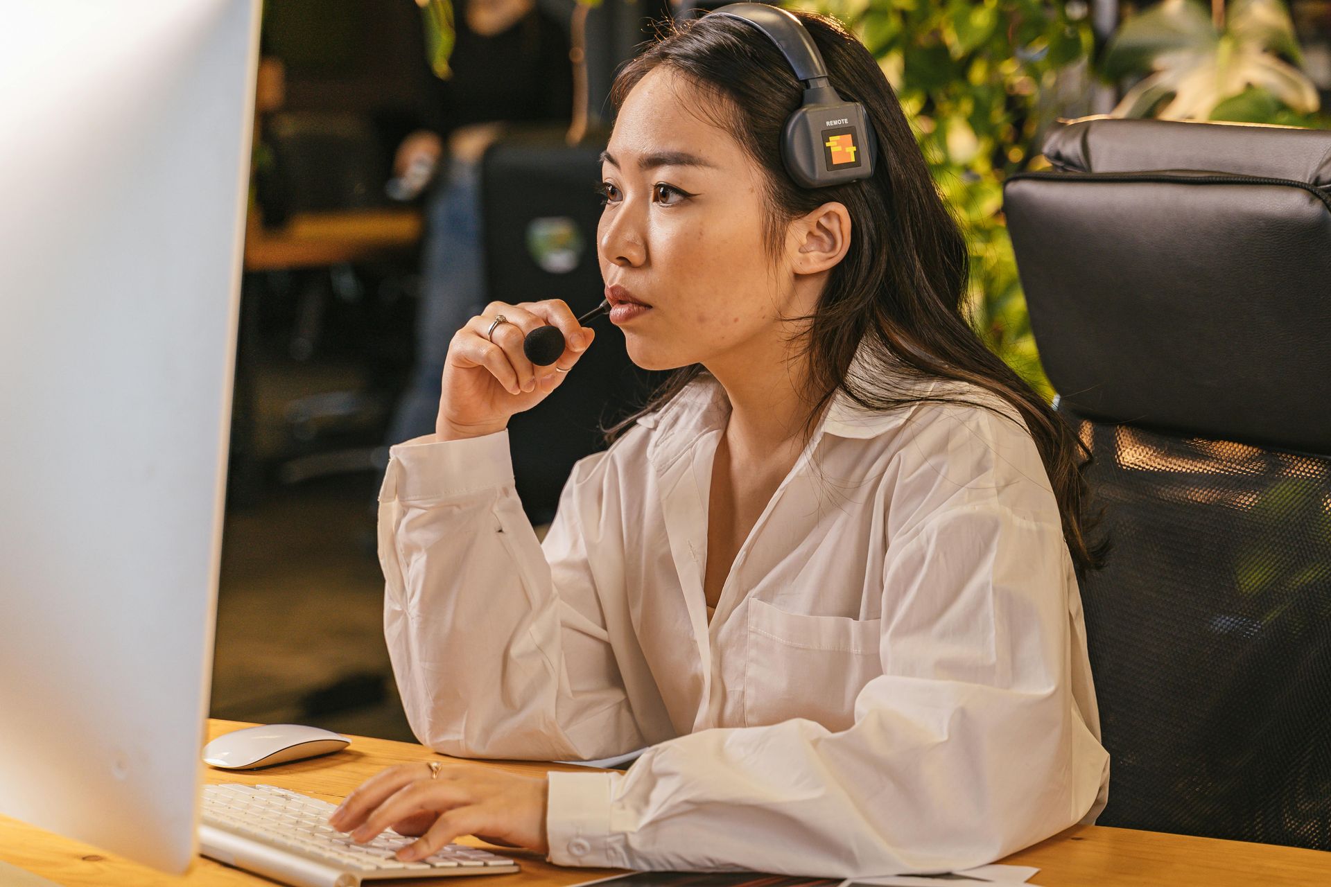 Person wearing headphones working at a desk in front of a computer monitor
