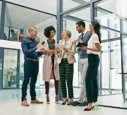 A group of people are standing next to each other in an office.