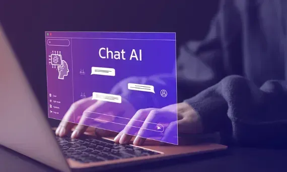 A person is typing on a laptop computer with a screen that says chat ai.