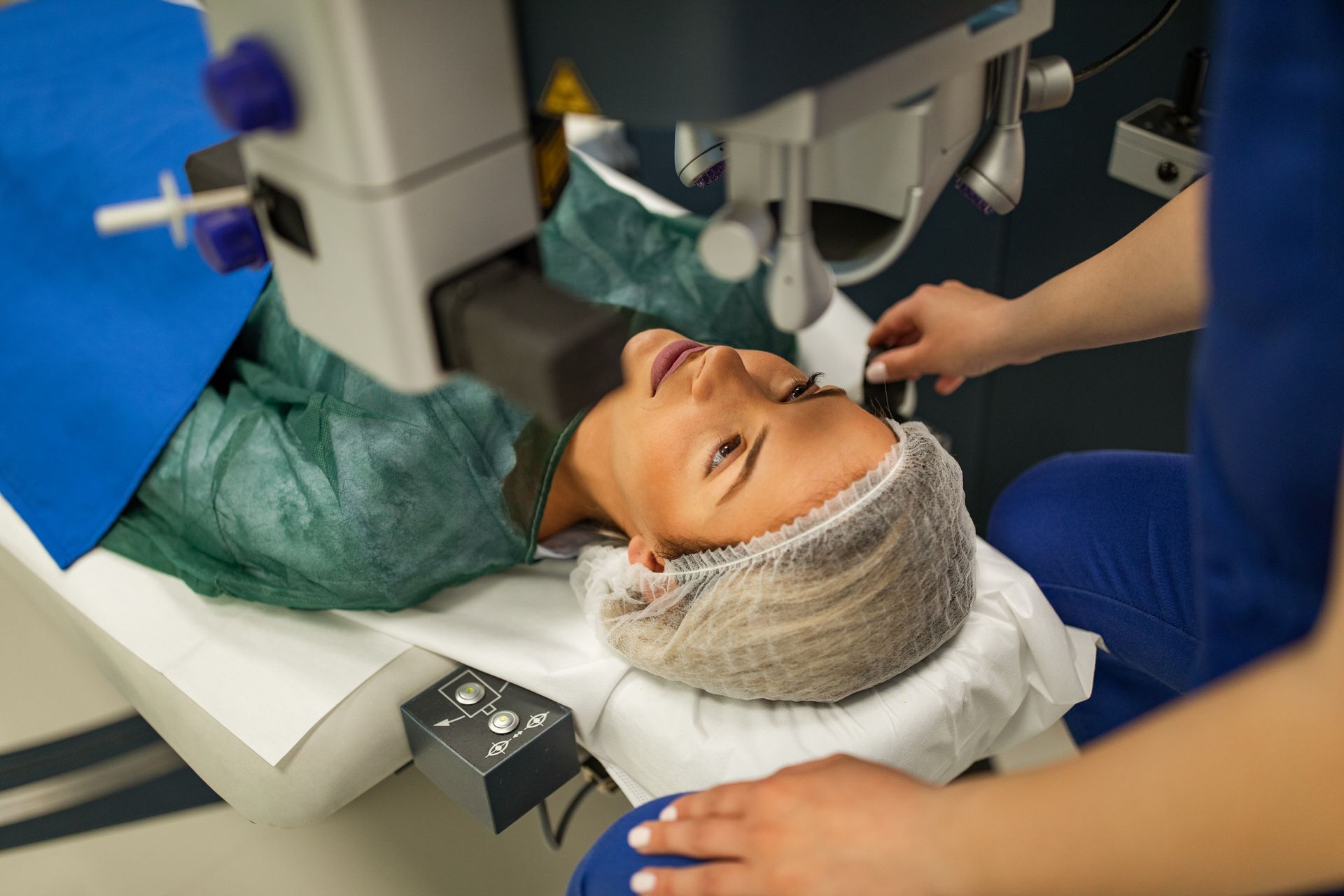 A woman is getting an eye surgery in a hospital.