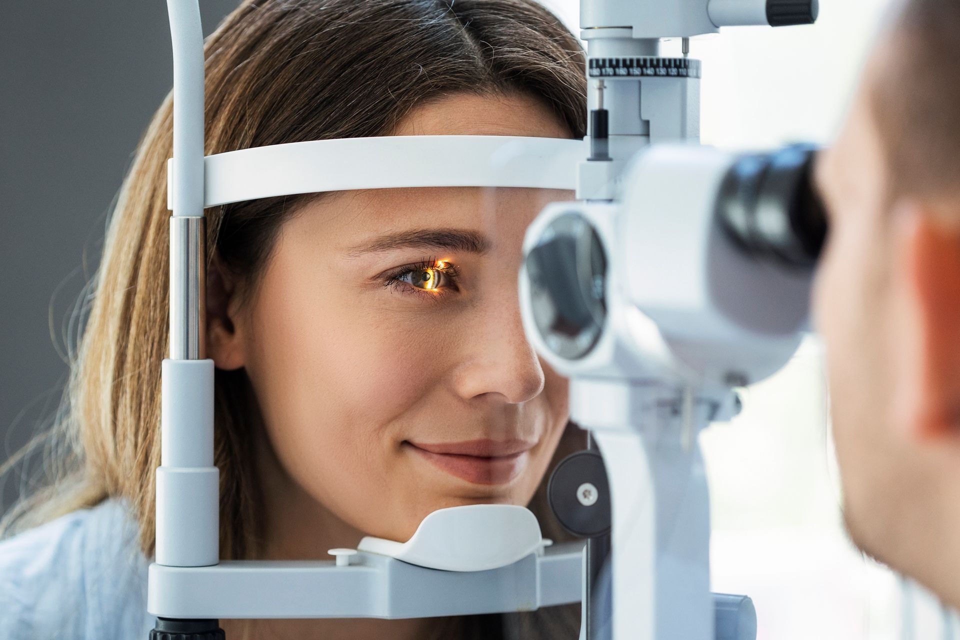 A woman is getting her eyes examined by an ophthalmologist.