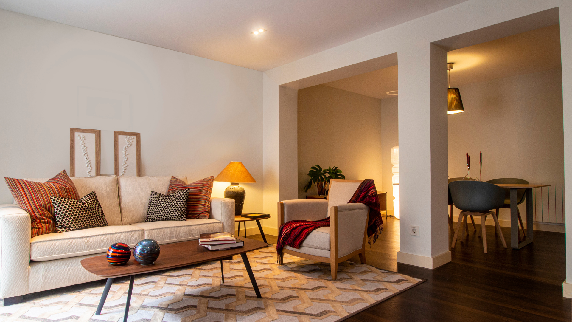 A living room with a couch , chair , coffee table and rug.