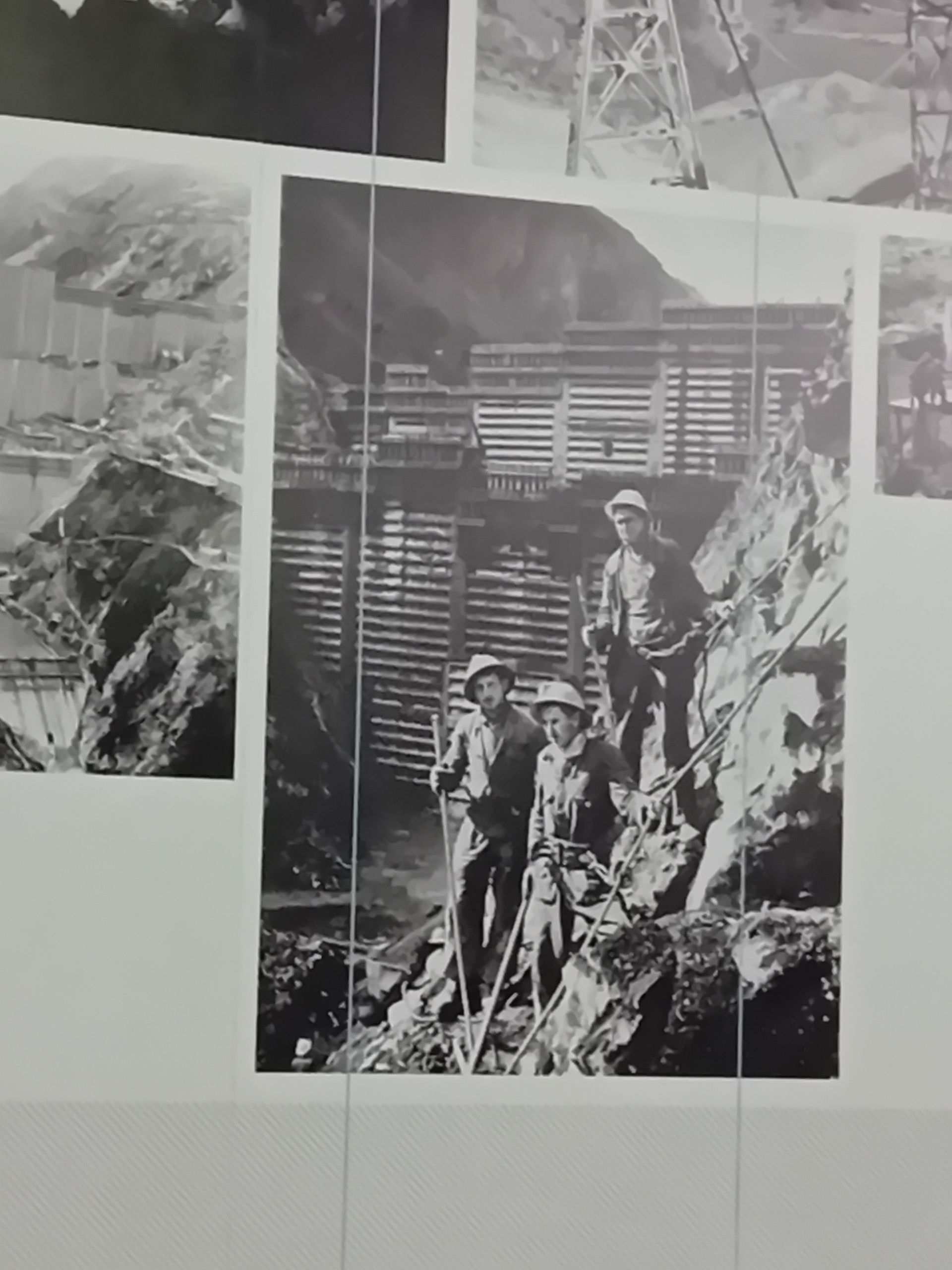 Ein Schwarzweißfoto von drei Männern, die auf einem Felsen stehen
