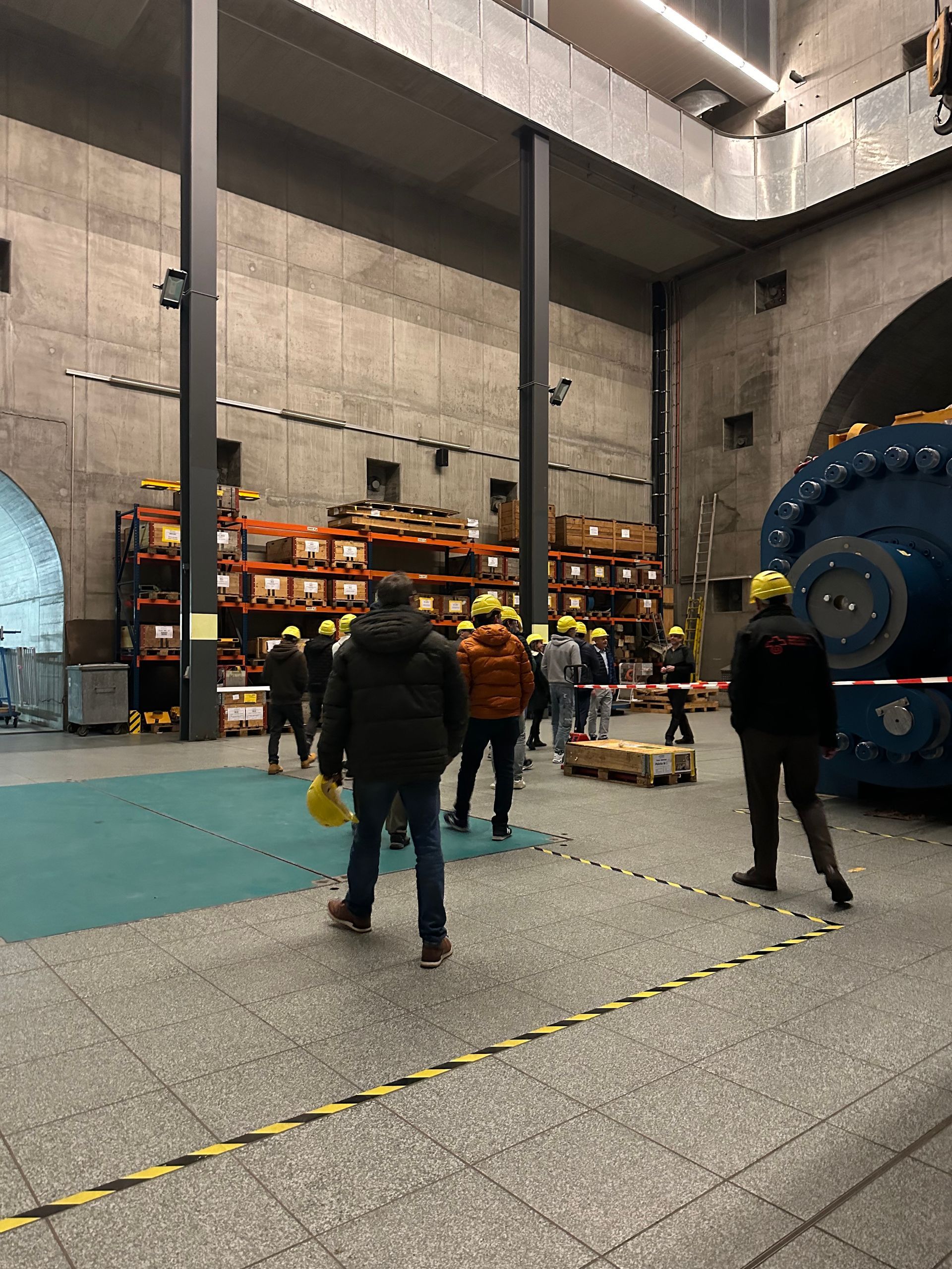 Eine Gruppe von Menschen steht in einem großen Raum in einer Fabrik.