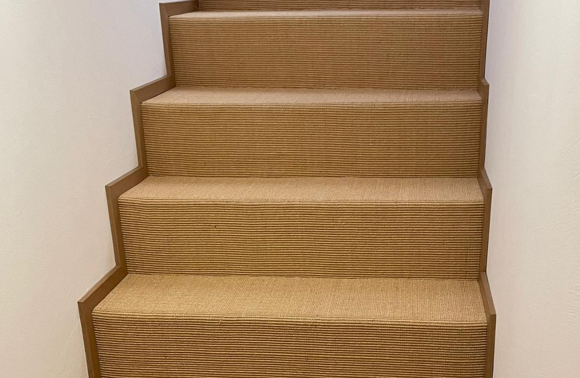 Un gros plan d'un escalier avec un tapis dessus.