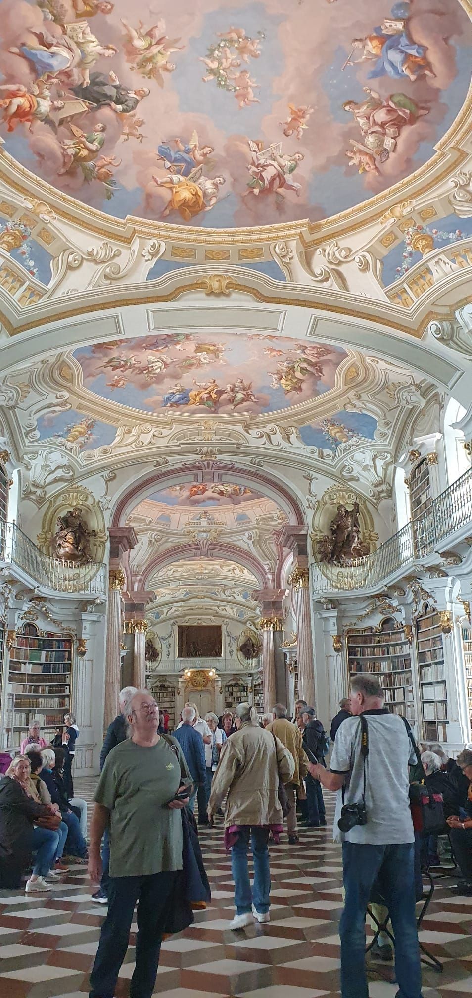 Les visiteurs pénètrent dans un hall orné d'un dôme aux teintes pastel, de fresques dorées et de colonnes de marbre.