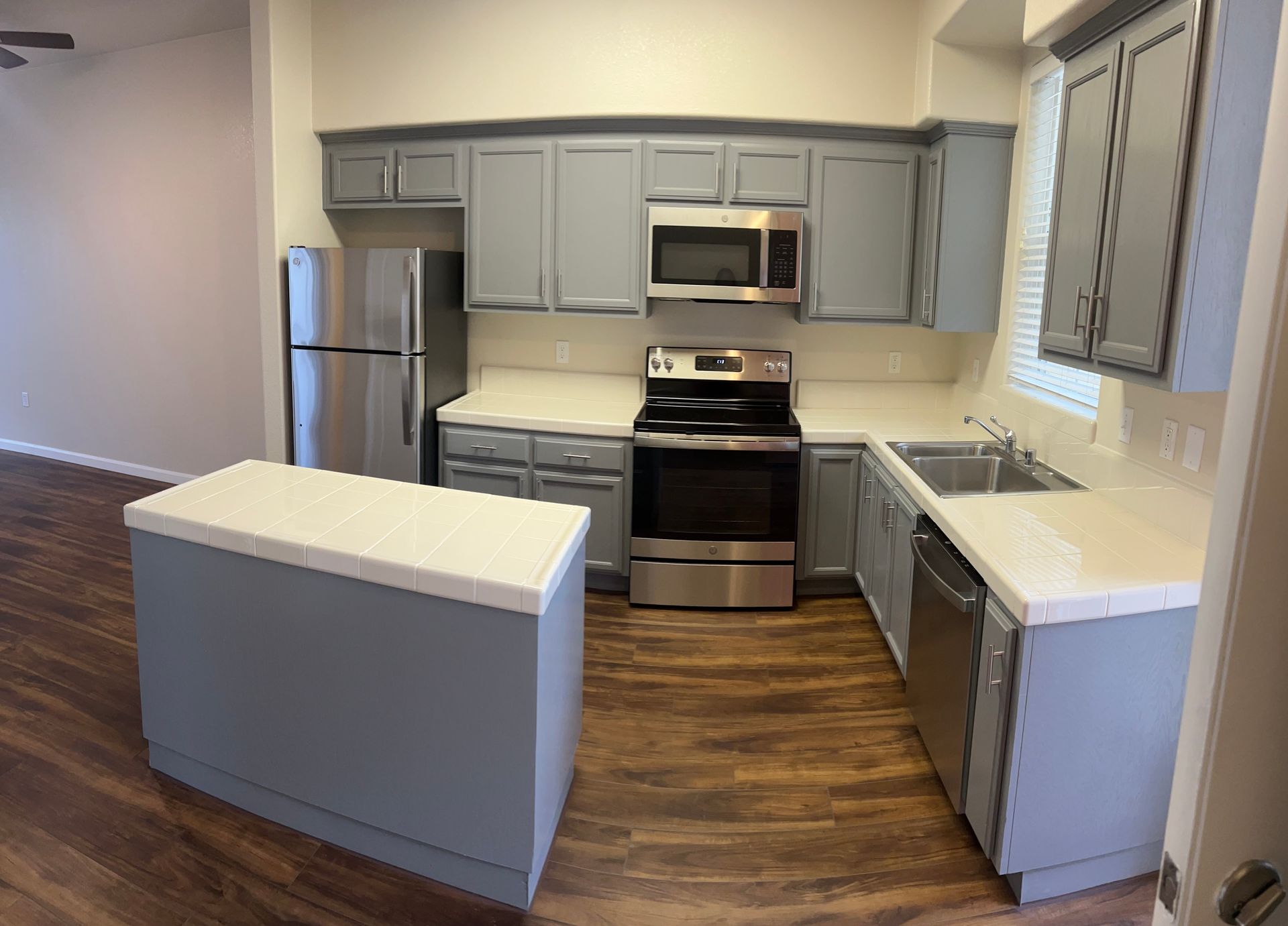 A kitchen with gray cabinets and stainless steel appliances