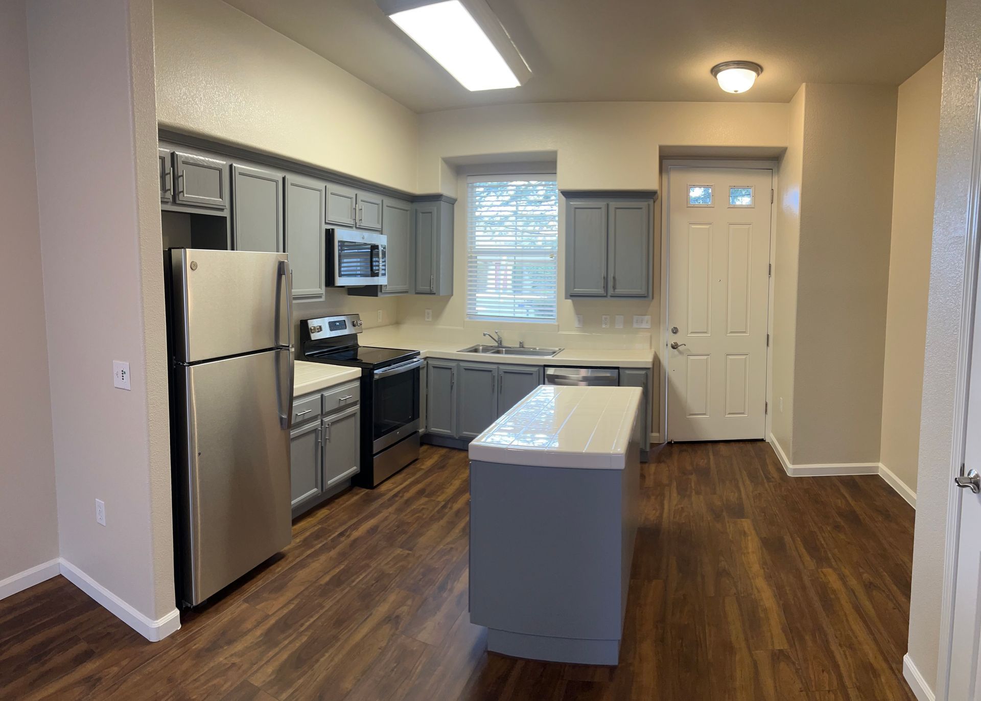A kitchen with stainless steel appliances and gray cabinets