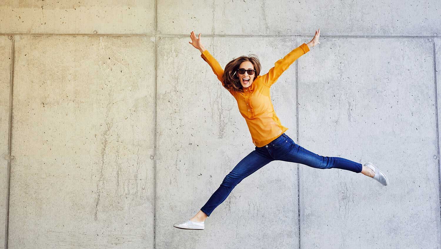A Woman is Jumping in the Air — Living Well Psychology Clinic in Erina, NSW