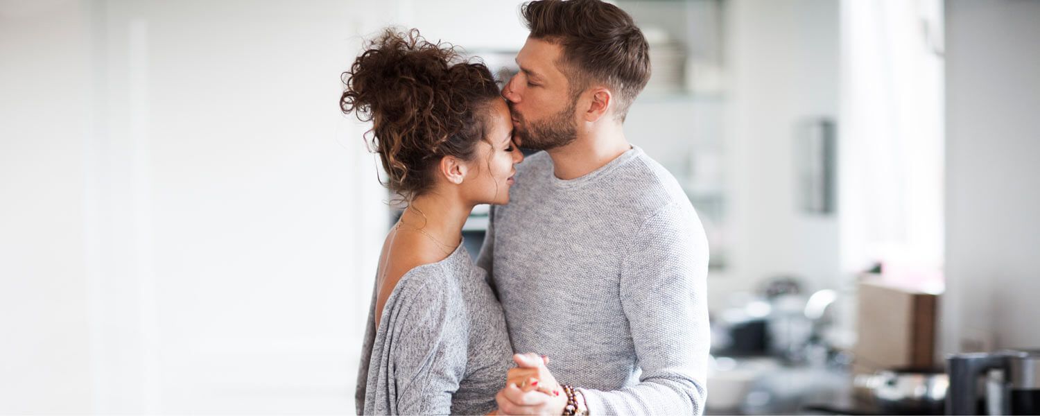 A Man is Kissing a Woman on the Forehead — Living Well Psychology Clinic in Erina, NSW