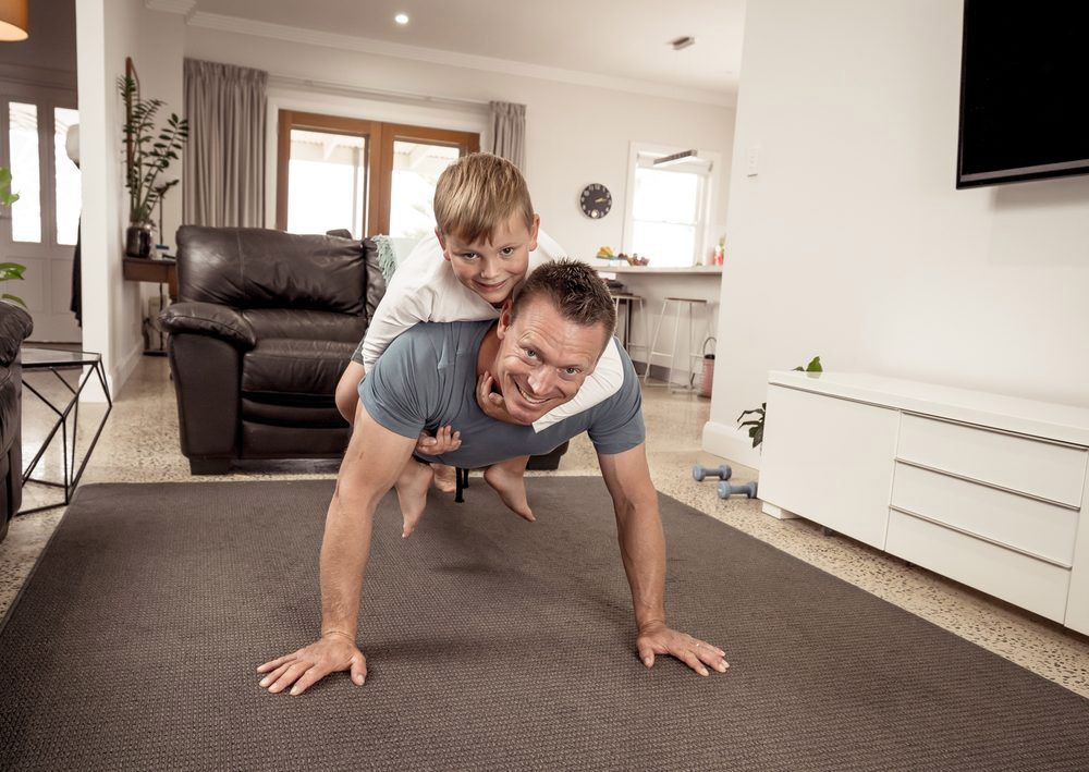 A Man and a Boy Are Doing Push Ups Together in a Living Room — Living Well Psychology Clinic in Erin