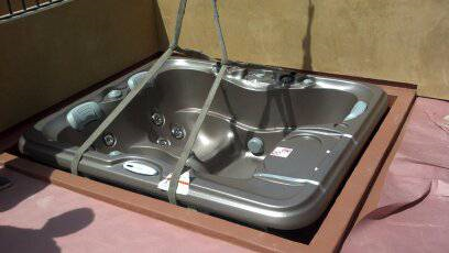 Stainless steel double sink in a cardboard box on a pink surface.