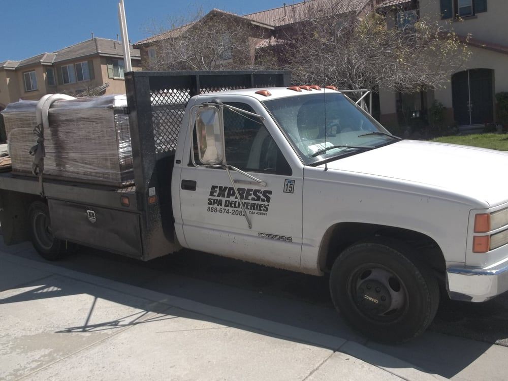 White delivery truck loaded with wrapped cargo parked on a residential street