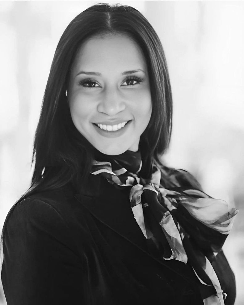 A black and white photo of a woman wearing a scarf around her neck
