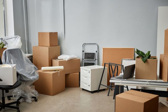 a room filled with lots of cardboard boxes and furniture .