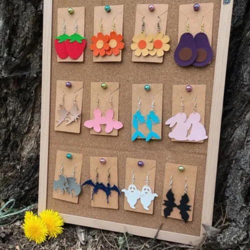 Handmade felt fruit and animal-shaped ornaments pinned to a corkboard display.