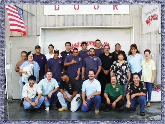 A group of people posing for a picture in front of a building that says door
