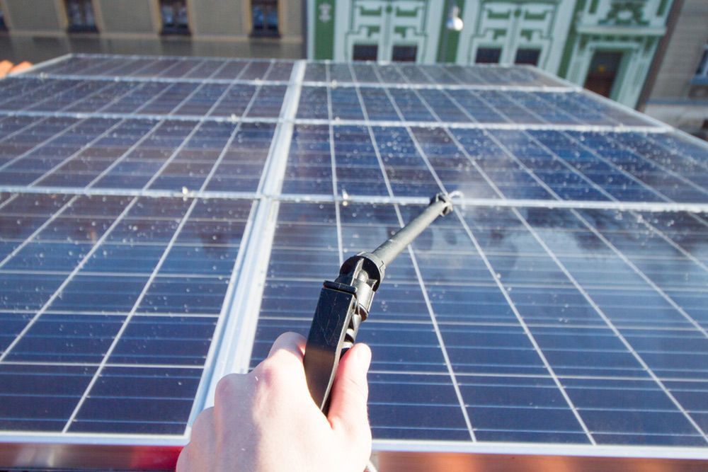 Cleaning the solar panel with water — Handyman in Huskisson, NSW