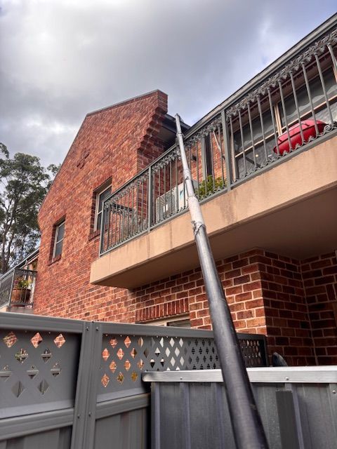 Man painting the top of the house — Handyman in Huskisson, NSW