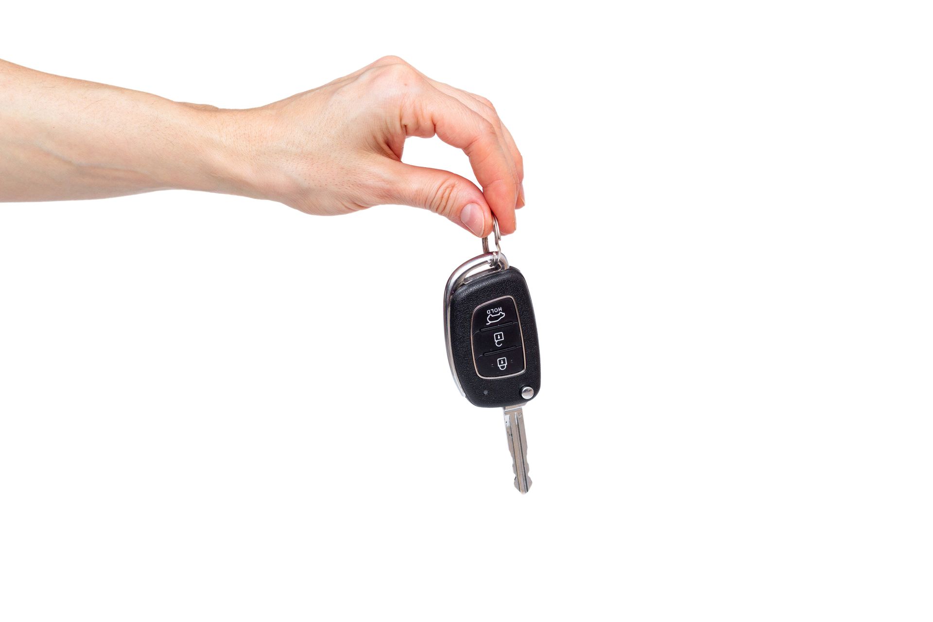 Hand holding a black car key fob with a metal key on a white background. Hand holding a black car key fob with a metal key on a white background.