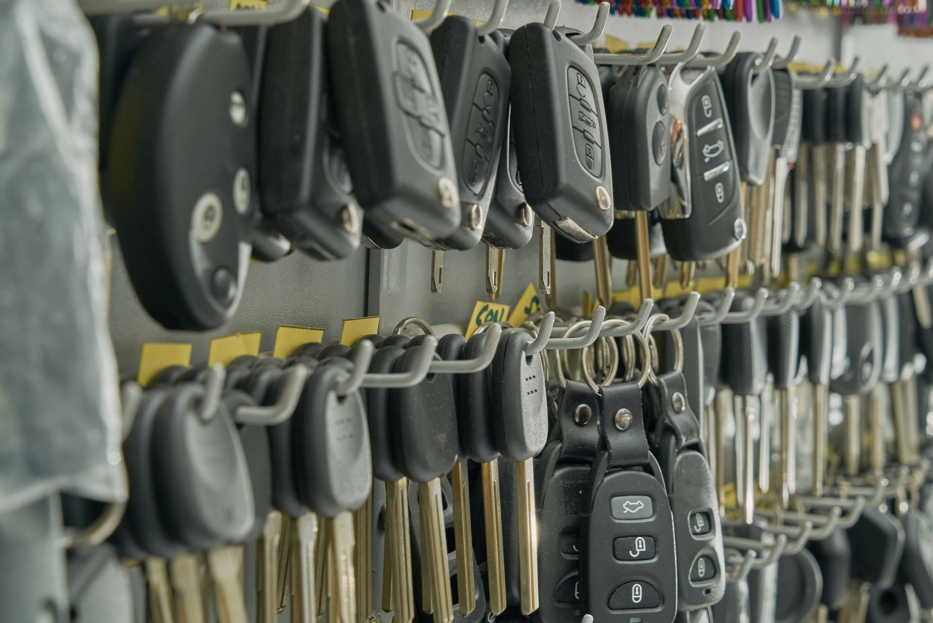 Row of hanging car keys and key fobs on a dealership display board. Row of hanging car keys and key fobs on a dealership display board.