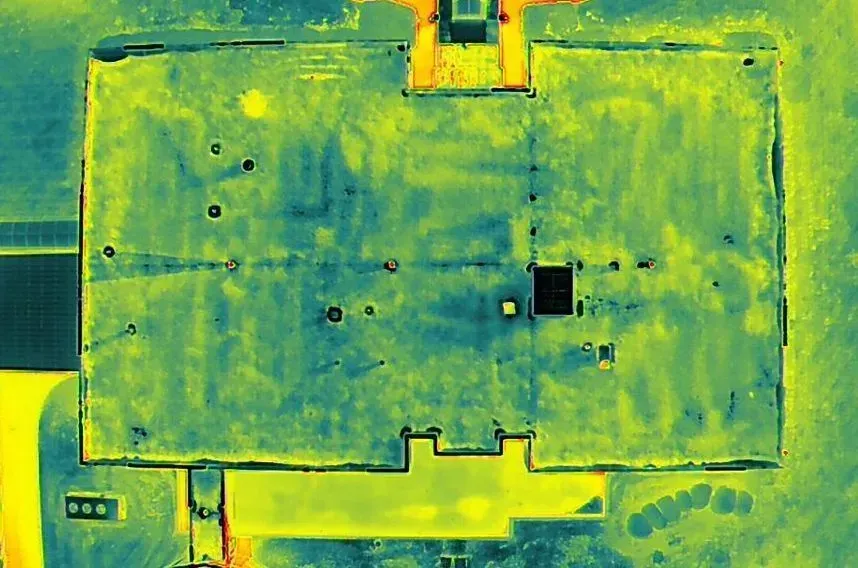 An aerial view of a building with a green and yellow roof.