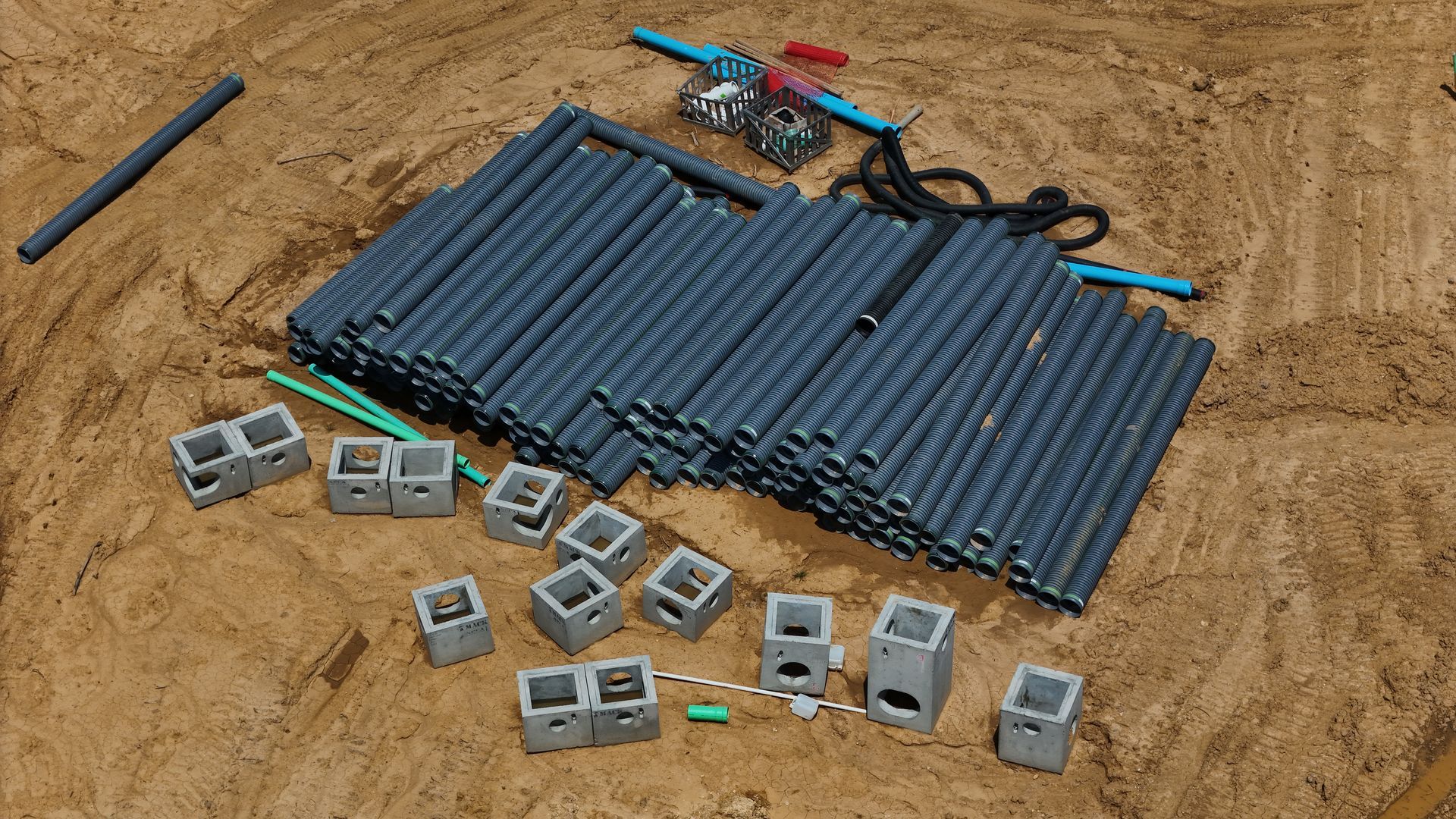 A pile of plastic pipes and blocks are laying on the ground. Inspected by drone.