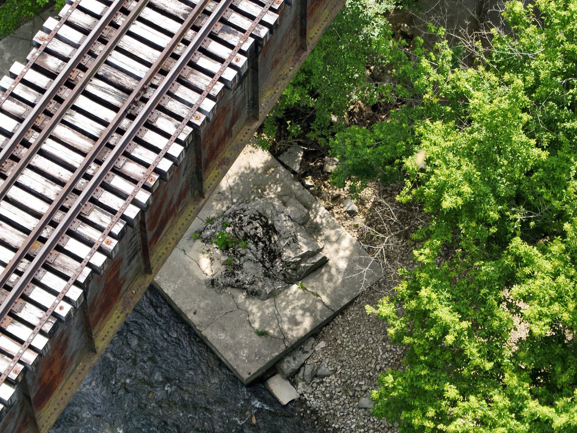 An aerial view of a train track with trees in the background. Inspected by drone.