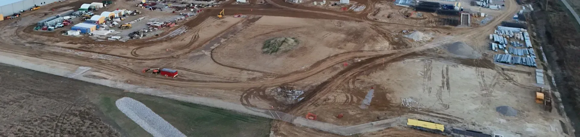 An aerial view of a construction site with a lot of dirt and trucks.