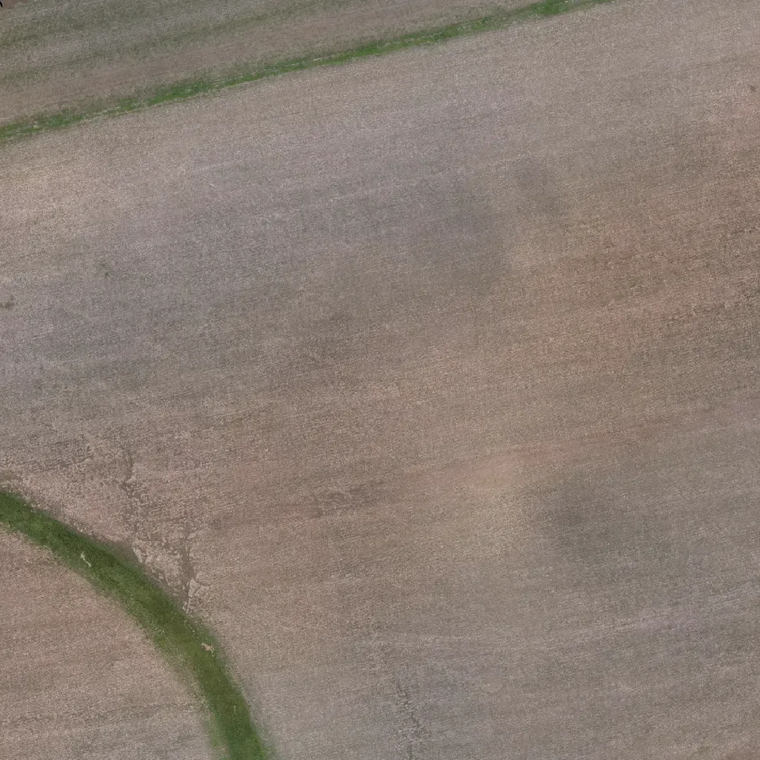 An aerial view of a field with a green line going through it.