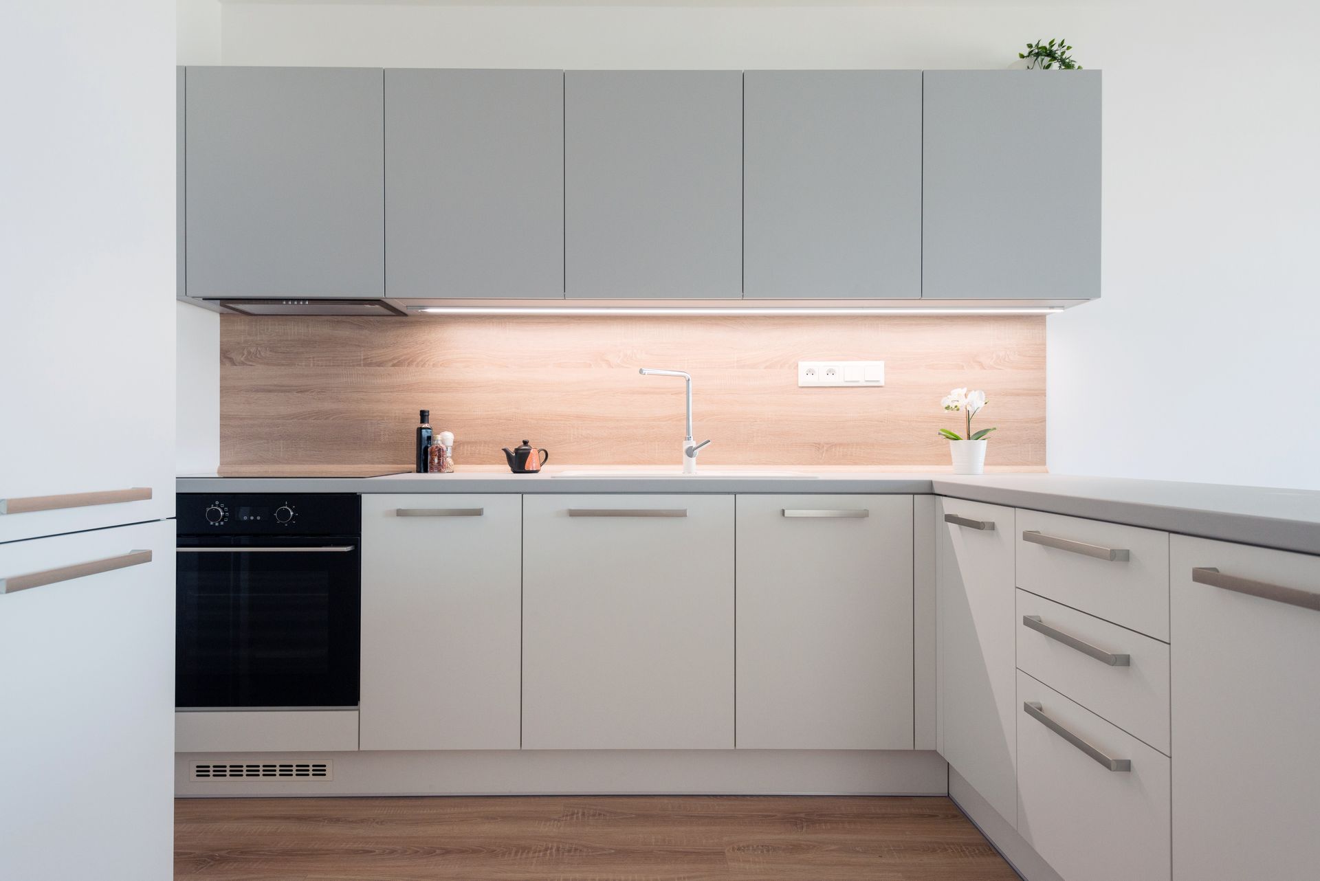 A kitchen with white cabinets and a black stove top oven.