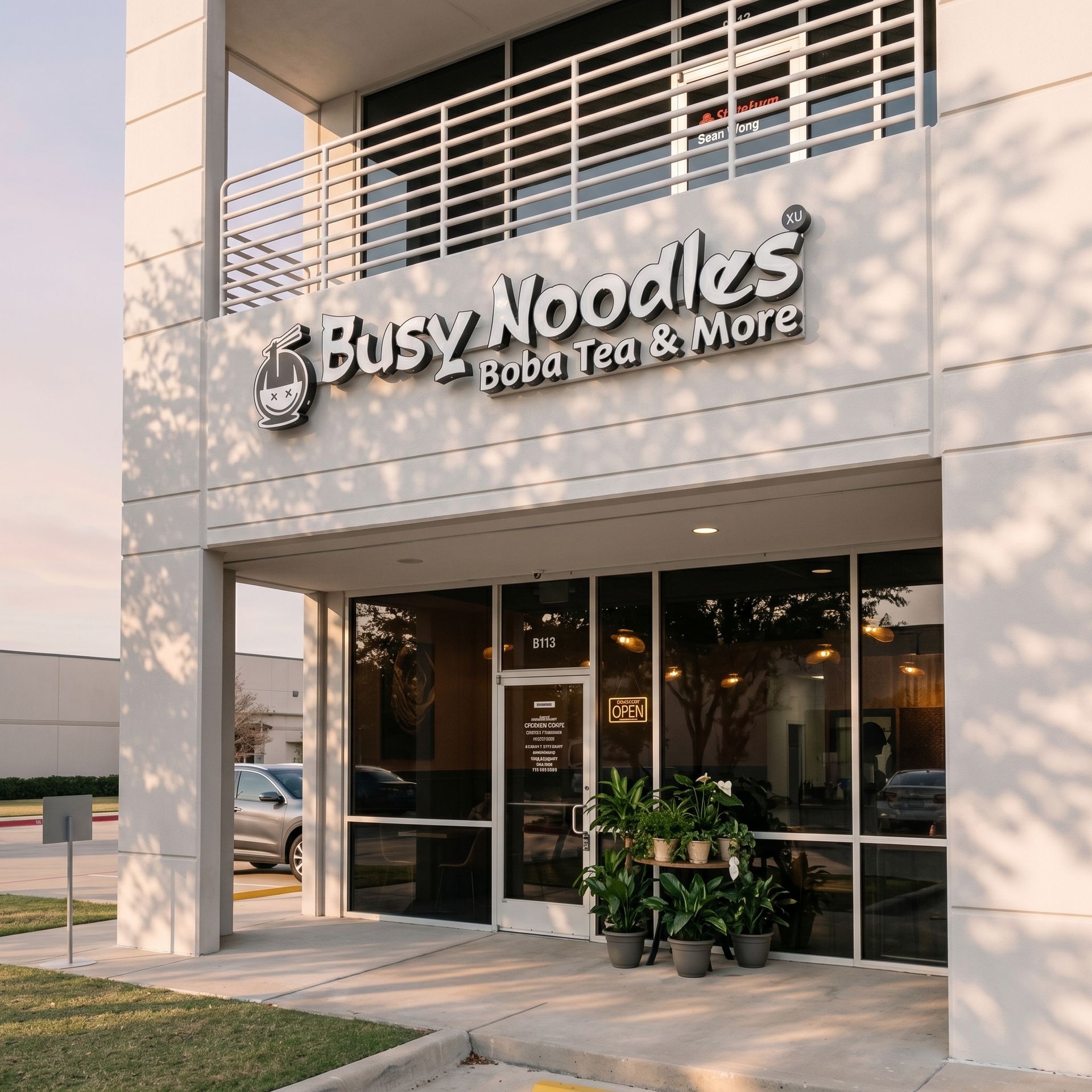 Busy Noodles Bubble Tea & More storefront with glass entrance, white facade, and potted plants outside
