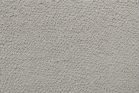 Close-up of a light gray textured surface with a rough, speckled pattern